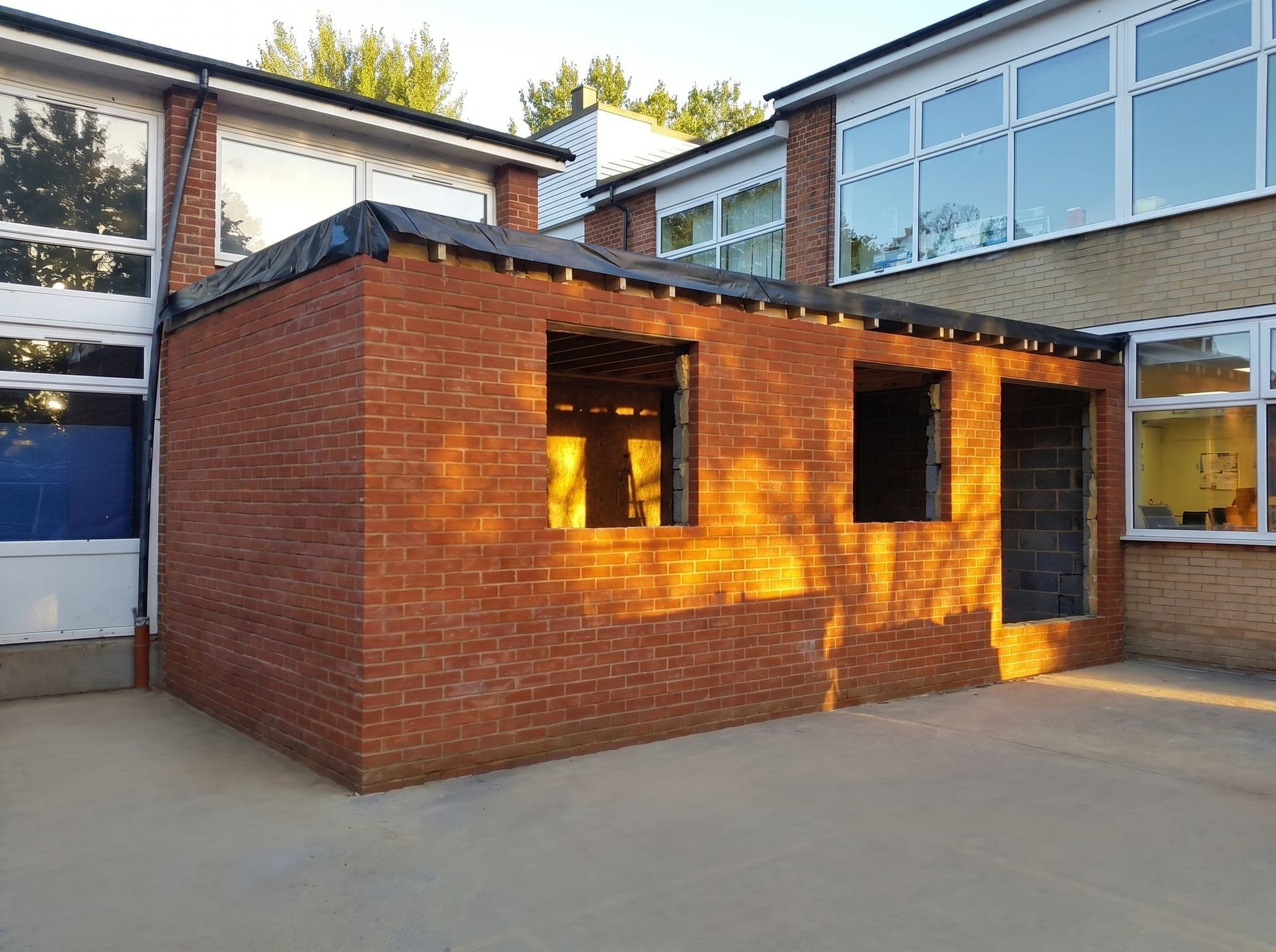 Same school extension partway through the build, with the brick shell complete and window openings still unglazed