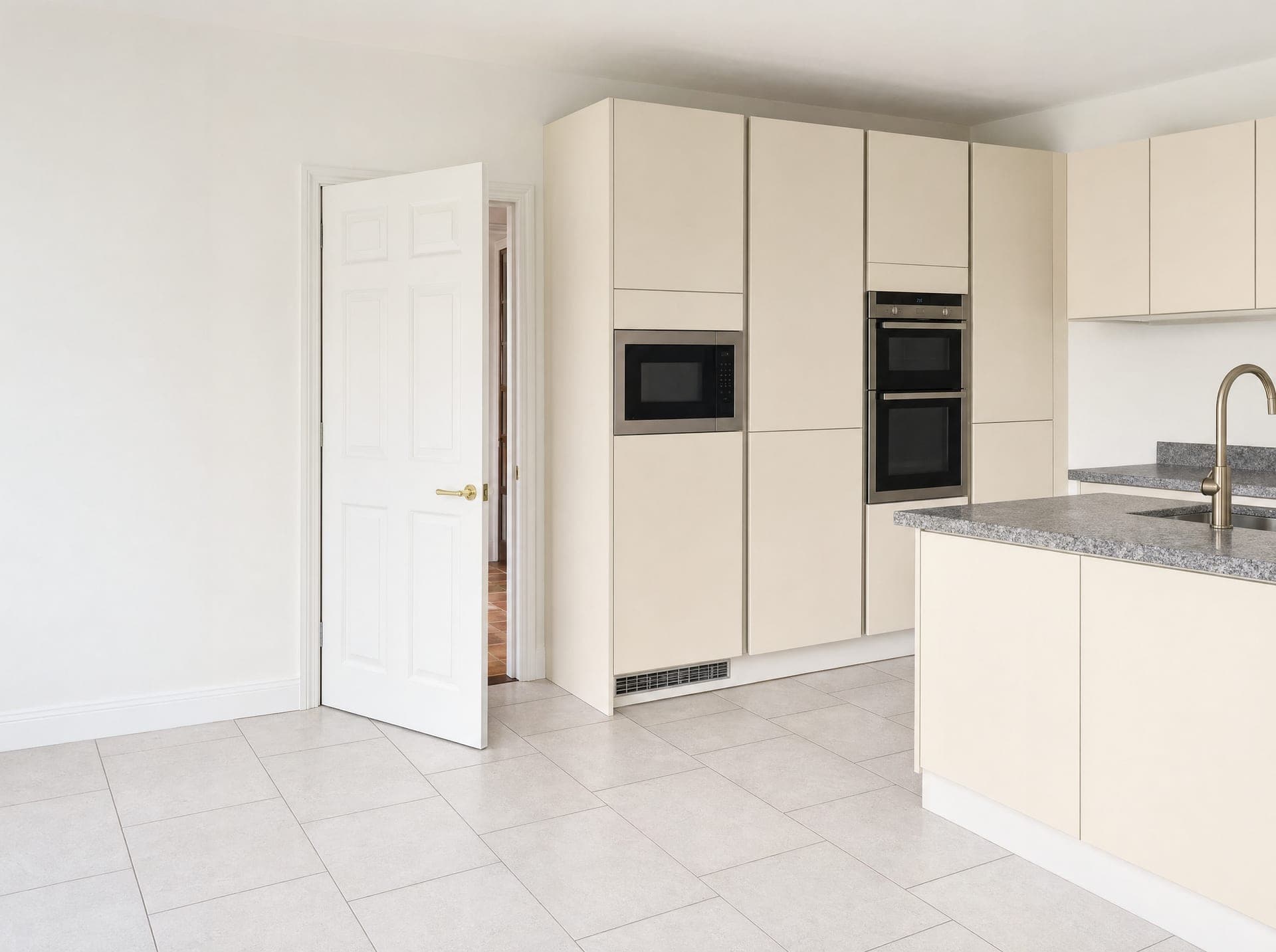 Cream handleless kitchen with integrated appliances and granite-effect island worktop